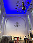 Ein weißer Kirchenraum mit leuchtend blau angestrahlter Decke.