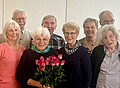 Senioren lächeln über einem Rosenstrauß