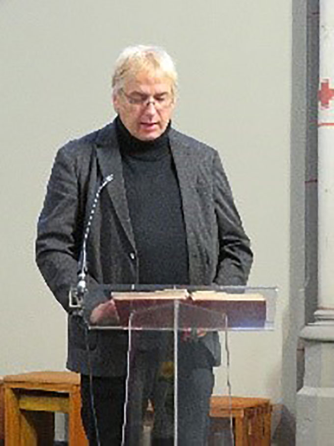 Andreas Funke, Flüchtlingsseelsorger des Bistums Aachen, steht am Rednerpult.